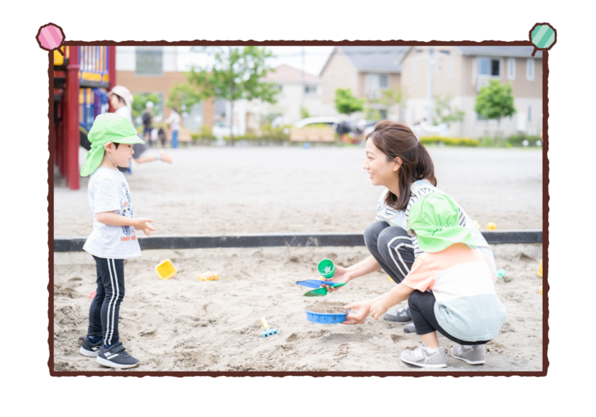 保育士と子どもたちが砂場で遊んでいる